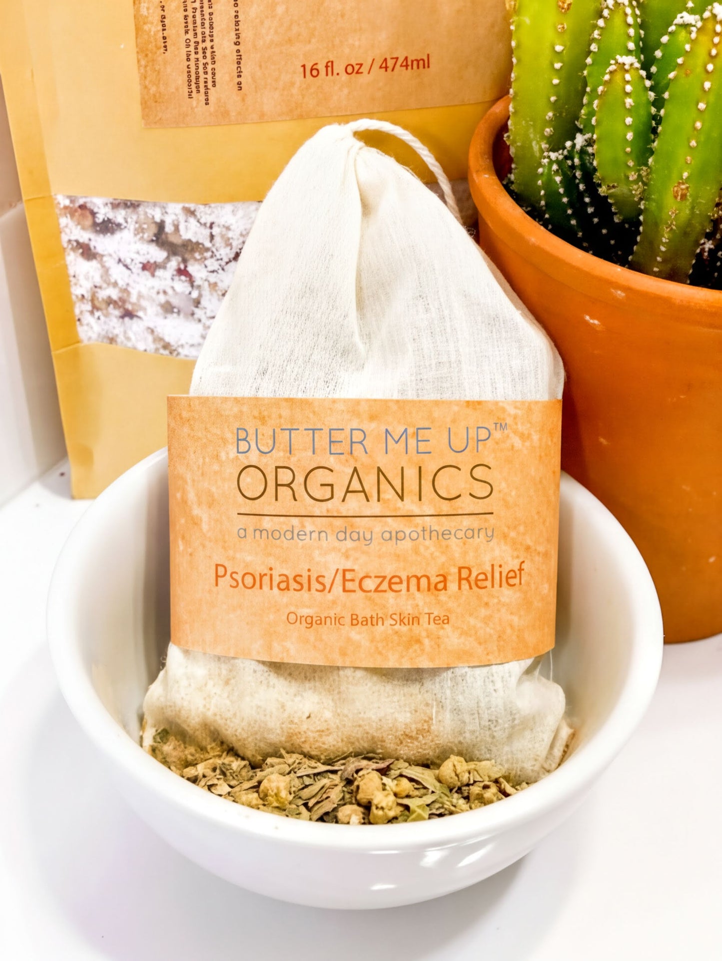 A white bowl filled with a mixture of herbs and spices sits on a white surface, with a bag of organic herbs and spices in the background.