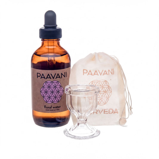 a brown glass bottle with a label that reads "PAAVANI", a clear glass cup, and a small white bag with a label that reads "PAAVANI".