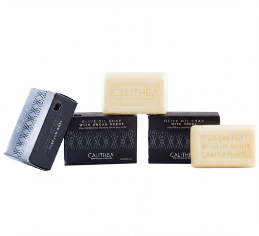 three soap bars and their packaging, with one soap bar lying on its side and the other two standing upright.