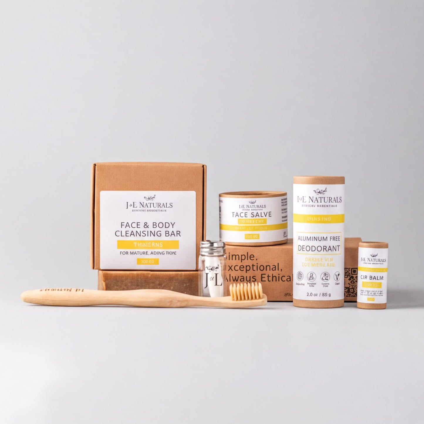 a collection of natural beauty products, including a face and body cleansing bar, a face balm, a deodorant, and a toothbrush, all arranged on a white background.