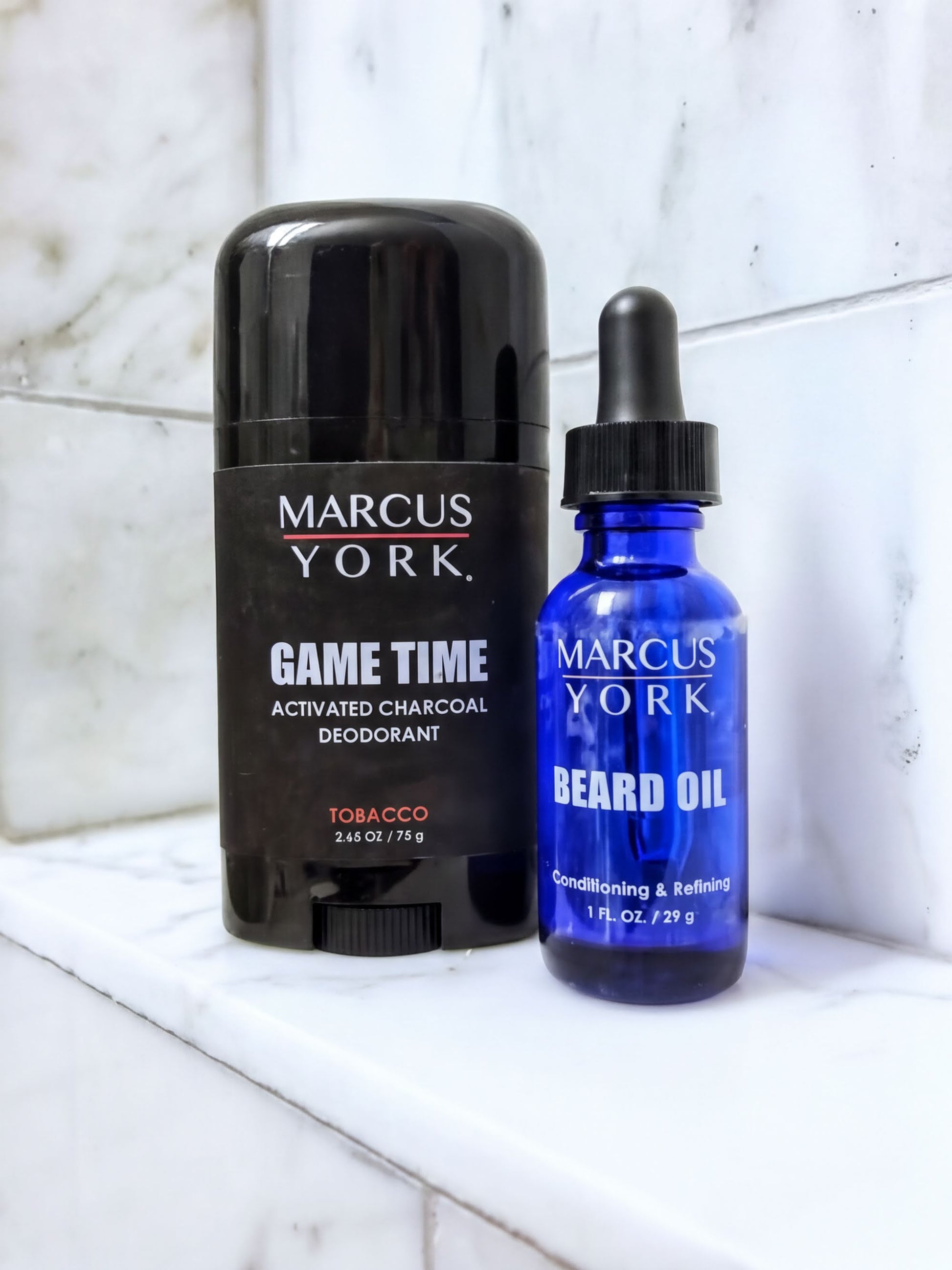 two grooming products from the brand Marcus York: a black deodorant stick and a blue beard oil bottle.