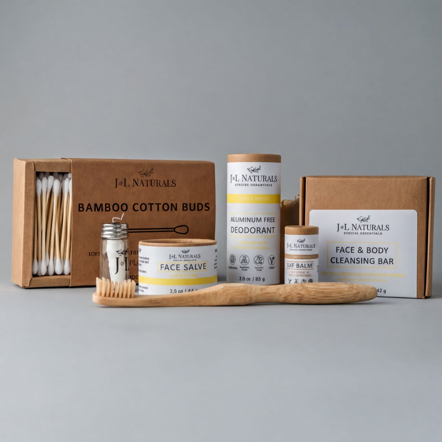 a collection of natural beauty products, including a bamboo toothbrush, a box of bamboo cotton buds, a jar of face balm, and a box of aluminum-free deodorant.