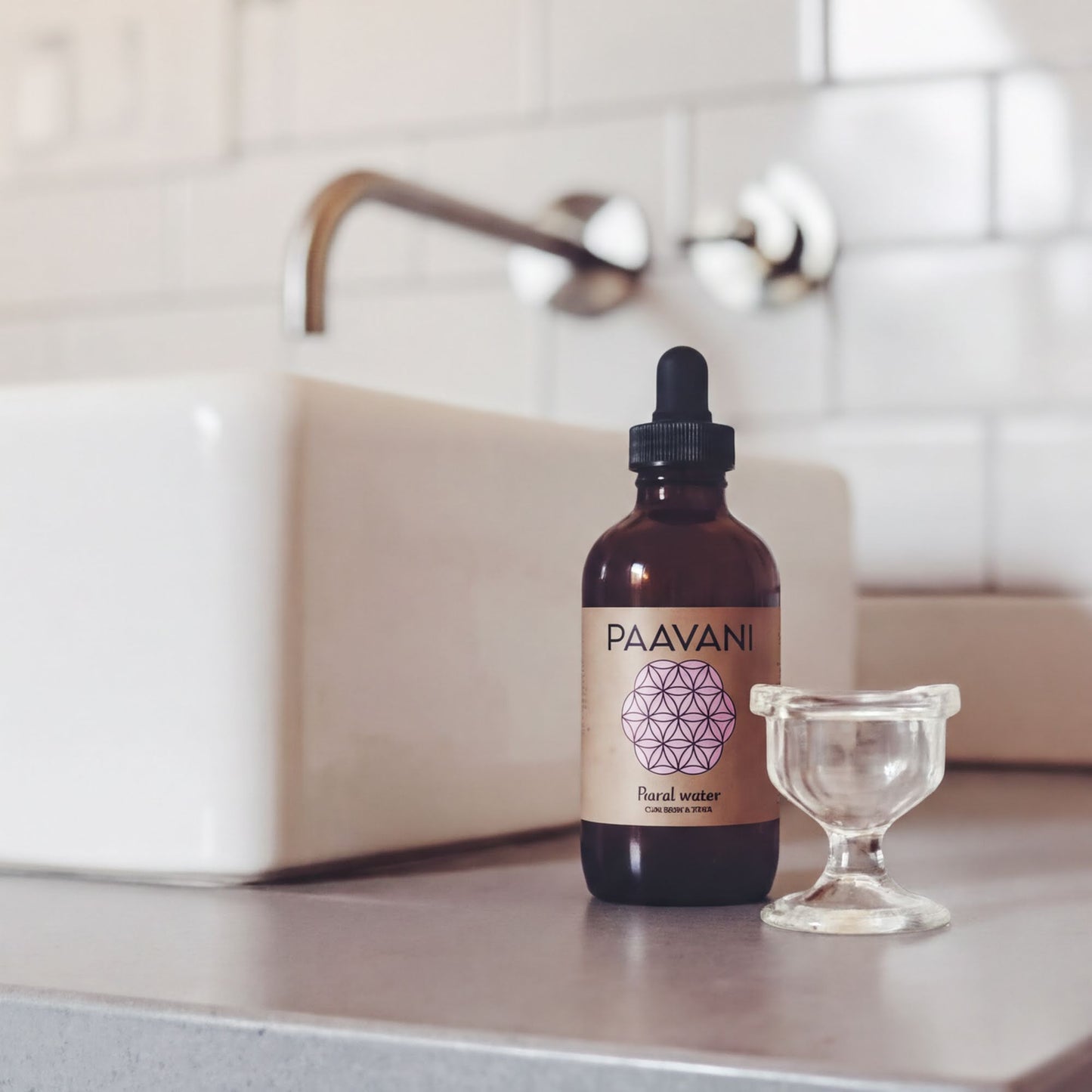 A brown bottle labeled "PAAVANI" and "Foral water" sits on a white countertop next to a small glass container.